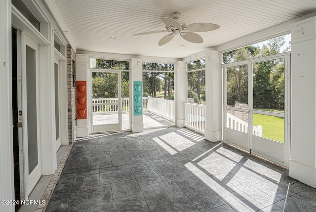 unfurnished sunroom featuring a wealth of natural light and ceiling fan