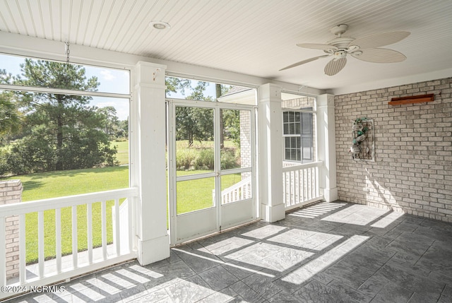 unfurnished sunroom with ceiling fan and a healthy amount of sunlight