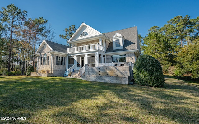 back of property featuring a lawn, a patio, a balcony, and a sunroom