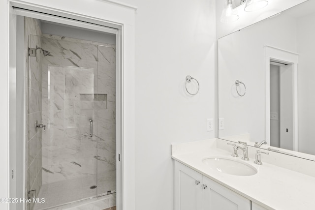 bathroom with a shower with shower door and vanity