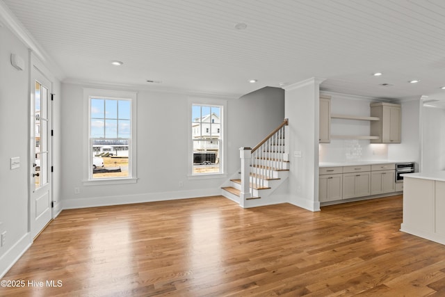 unfurnished living room with light hardwood / wood-style flooring and crown molding