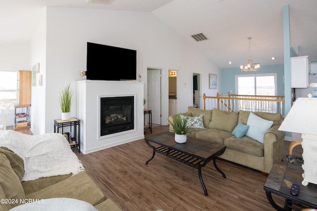 living room with a notable chandelier, dark hardwood / wood-style floors, and high vaulted ceiling