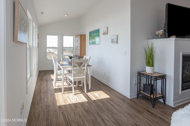 dining room with vaulted ceiling and dark hardwood / wood-style flooring