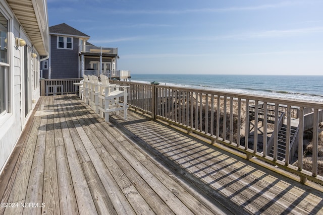 wooden deck with a beach view and a water view