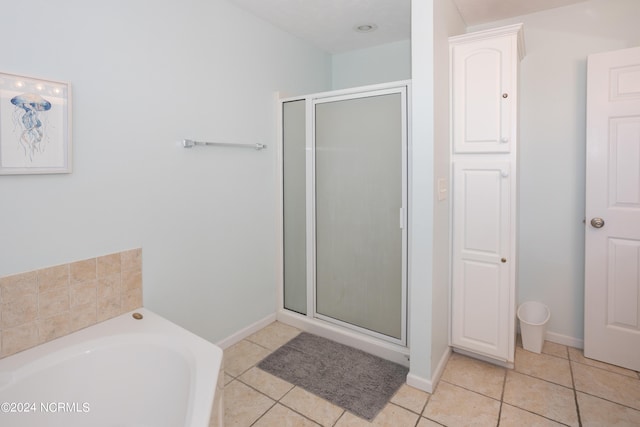 bathroom with shower with separate bathtub and tile flooring