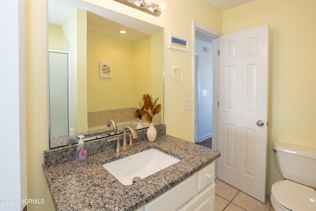 bathroom featuring toilet, vanity, and tile flooring