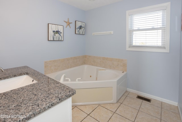 bathroom featuring tile floors, vanity, and a tub