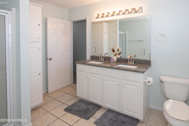 bathroom featuring double sink vanity, toilet, and tile flooring