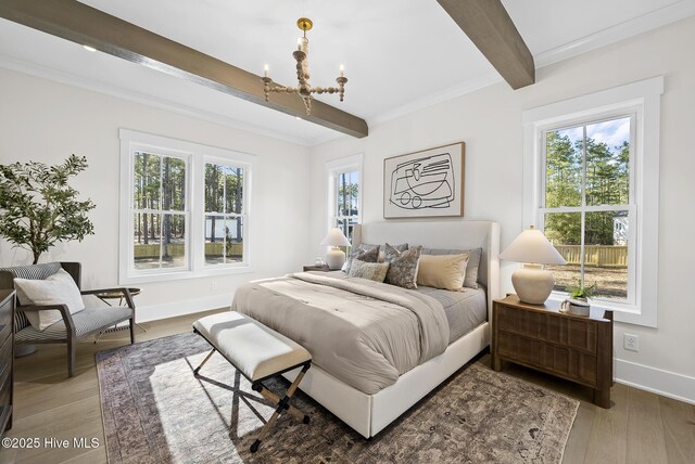 bedroom with beamed ceiling, a notable chandelier, wood finished floors, and baseboards