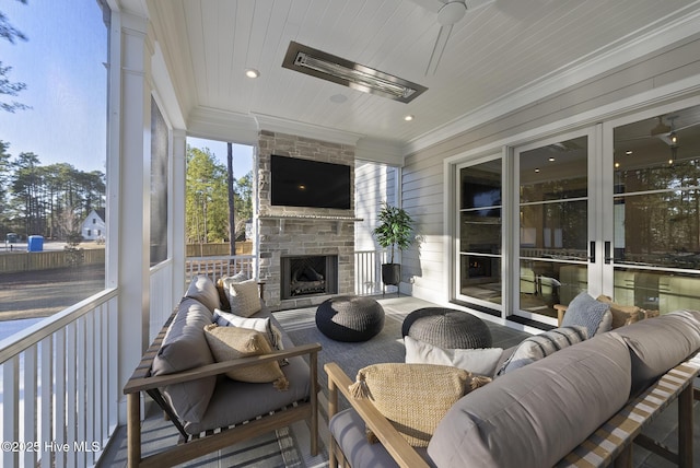 sunroom / solarium featuring wood ceiling and an outdoor stone fireplace