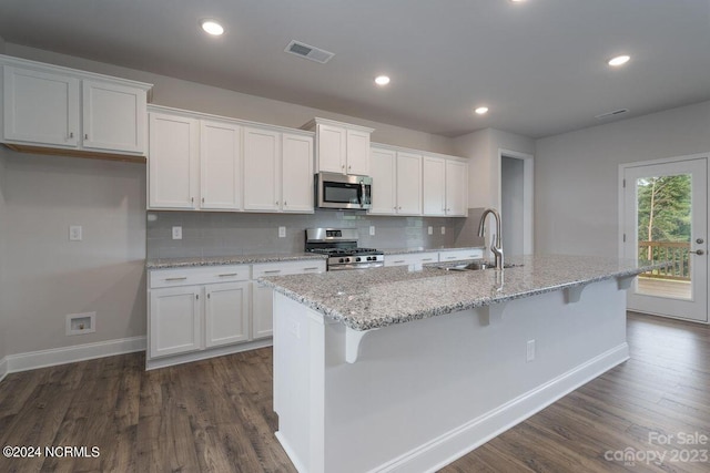 kitchen featuring an island with sink, sink, dark wood-type flooring, white cabinetry, and stainless steel appliances