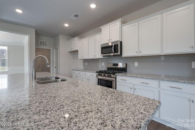 kitchen featuring white cabinets, visible vents, appliances with stainless steel finishes, and a sink