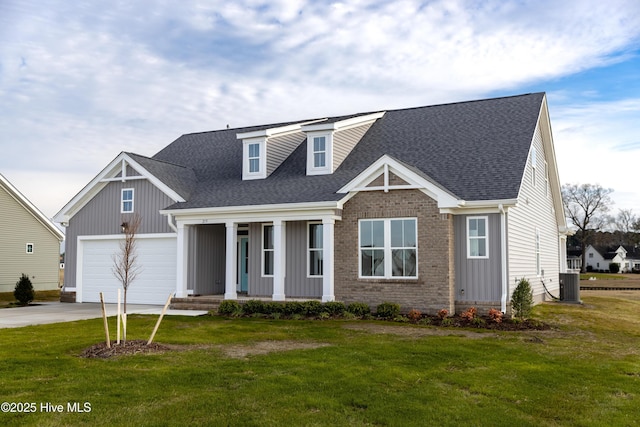 view of front facade featuring covered porch, a front yard, a garage, and central air condition unit