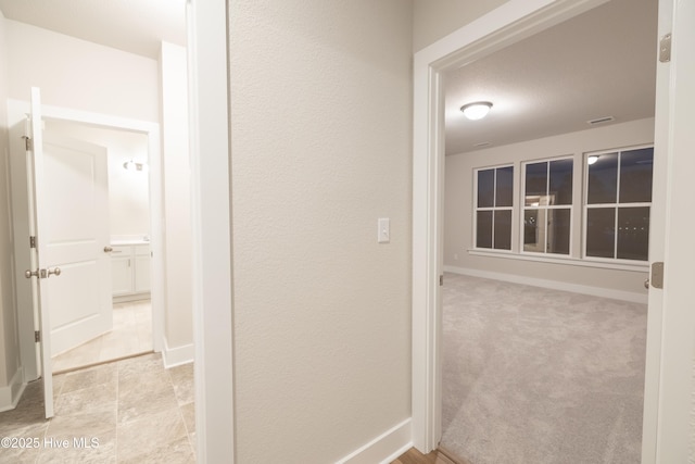 hallway with light colored carpet