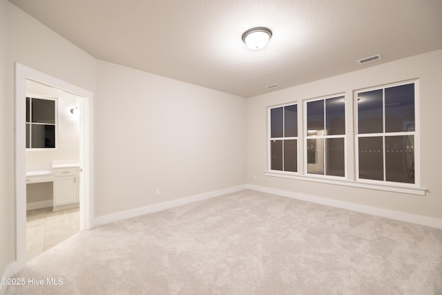 carpeted spare room with a textured ceiling