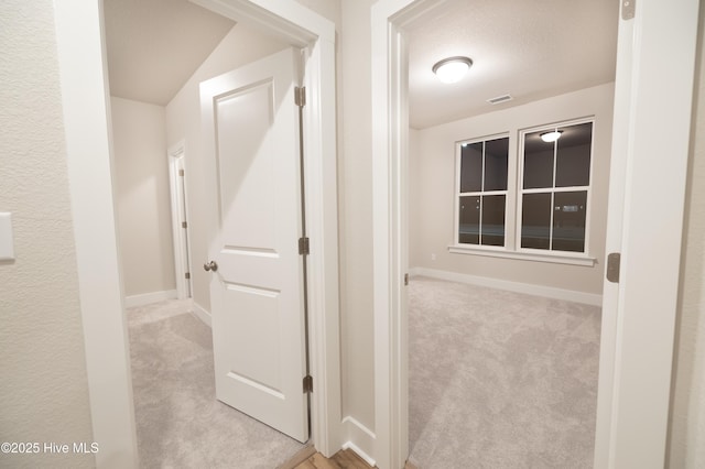 hallway featuring light carpet