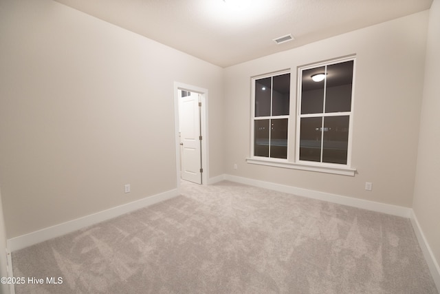 unfurnished room featuring light carpet