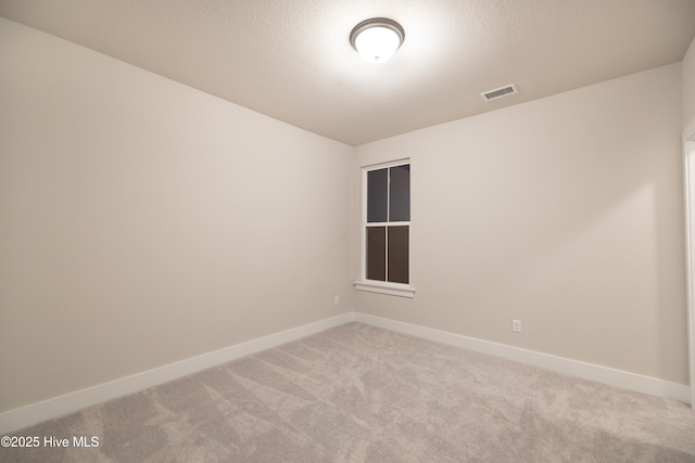 unfurnished room with a textured ceiling and light colored carpet