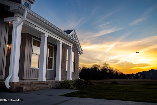 property exterior at dusk featuring a yard