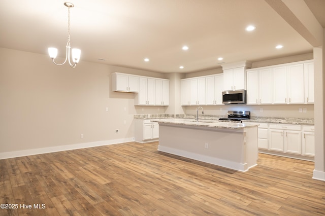 kitchen featuring sink, white cabinets, stainless steel appliances, and light hardwood / wood-style flooring