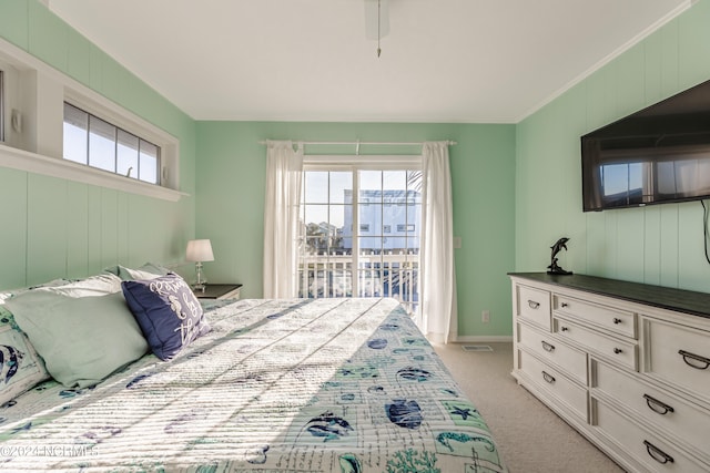 bedroom featuring light carpet, multiple windows, access to exterior, and ceiling fan