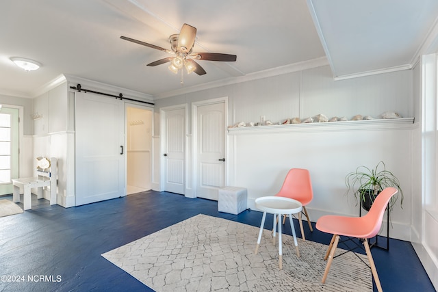 sitting room featuring ornamental molding, ceiling fan, and a barn door