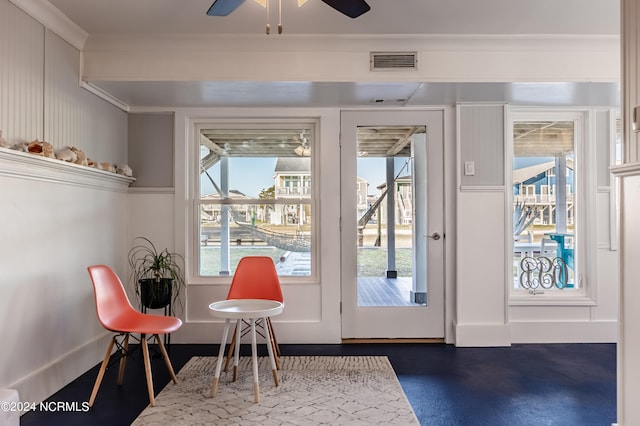 doorway to outside with ornamental molding and ceiling fan