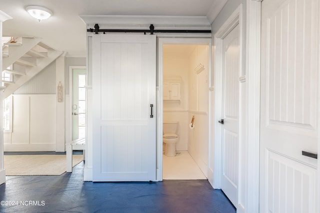 interior space with crown molding and a barn door