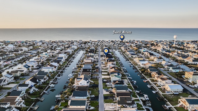 aerial view at dusk featuring a water view