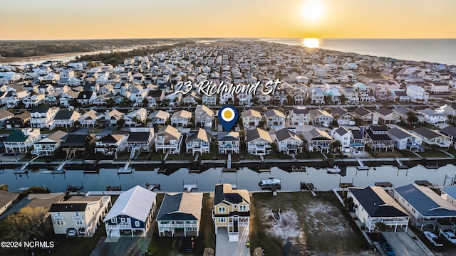 aerial view at dusk featuring a water view