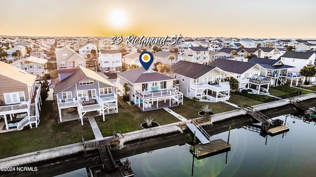 aerial view at dusk featuring a water view