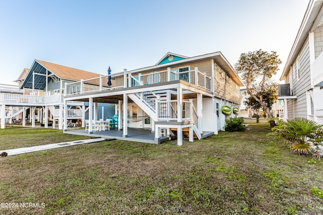 back of house featuring a lawn, a patio area, and a deck