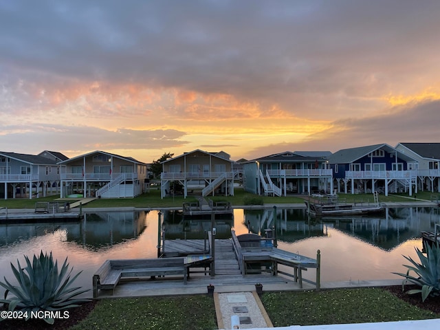 dock area with a lawn and a water view