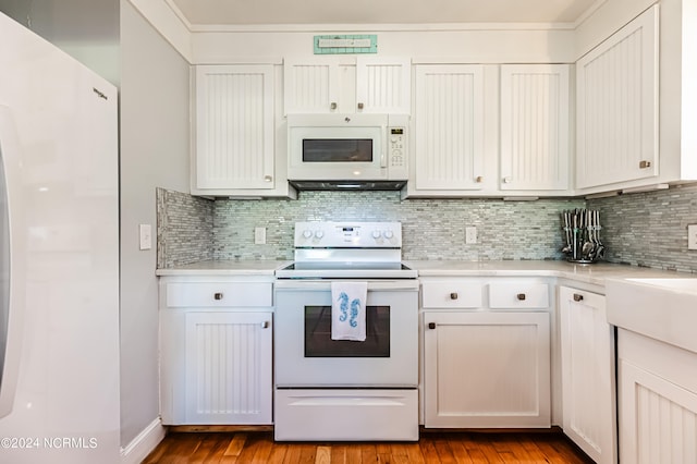 kitchen with white appliances, tasteful backsplash, light hardwood / wood-style flooring, and white cabinets