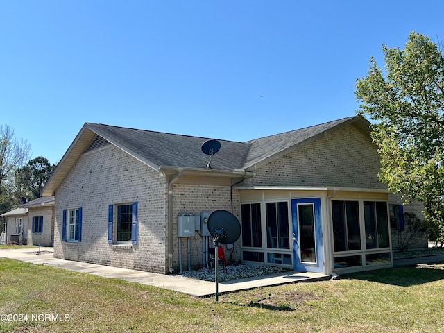 back of property featuring central AC unit, a lawn, and a sunroom