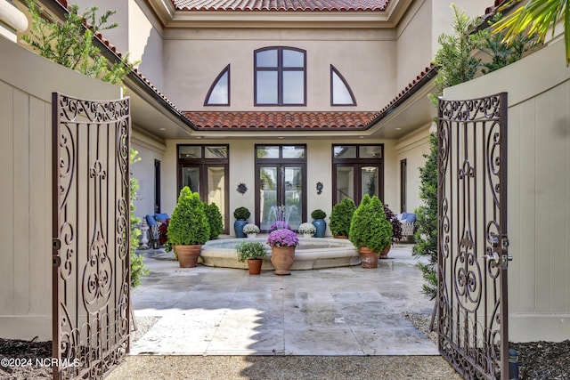 view of exterior entry with a patio and french doors