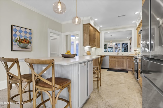 kitchen with appliances with stainless steel finishes, decorative light fixtures, backsplash, a kitchen breakfast bar, and crown molding