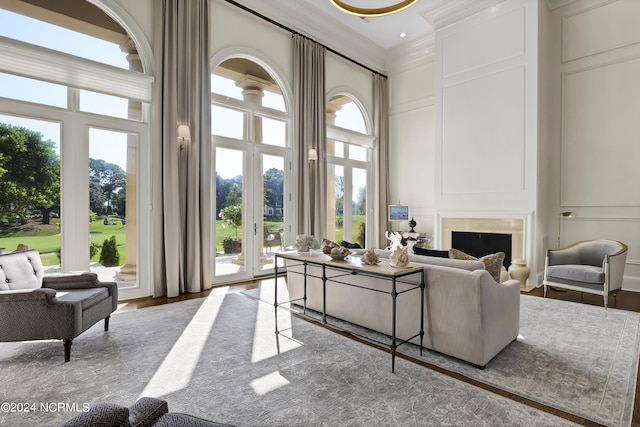 living room with ornamental molding, hardwood / wood-style floors, and a high ceiling