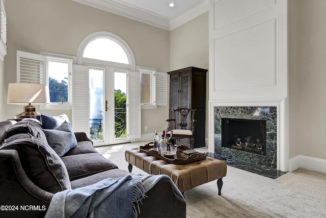 living room featuring crown molding, a high ceiling, a fireplace, light carpet, and french doors