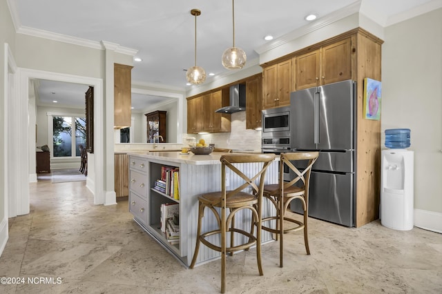 kitchen with tasteful backsplash, decorative light fixtures, appliances with stainless steel finishes, a kitchen breakfast bar, and wall chimney range hood