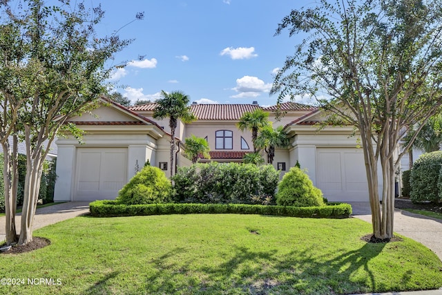 mediterranean / spanish-style house with a garage and a front yard