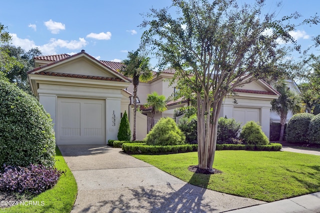 view of front of home with a garage and a front lawn