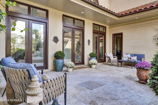 view of exterior entry with french doors, an outdoor hangout area, and a patio area