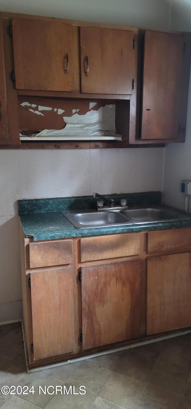 kitchen with dark countertops, brown cabinets, and a sink