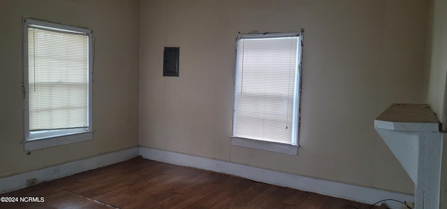 empty room featuring dark wood-style floors and electric panel