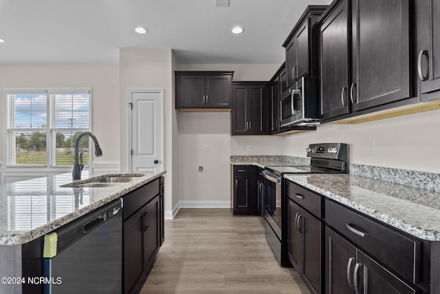 kitchen featuring light stone countertops, dishwashing machine, electric range, and sink