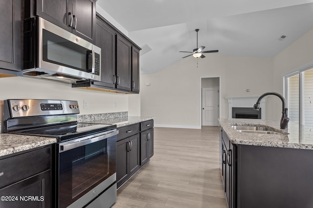 kitchen with appliances with stainless steel finishes, lofted ceiling, sink, light wood-type flooring, and ceiling fan