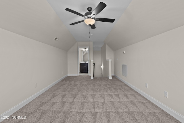 interior space featuring vaulted ceiling, ceiling fan, and light colored carpet