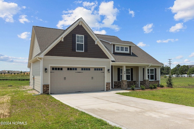 craftsman house featuring a front lawn, a garage, and covered porch