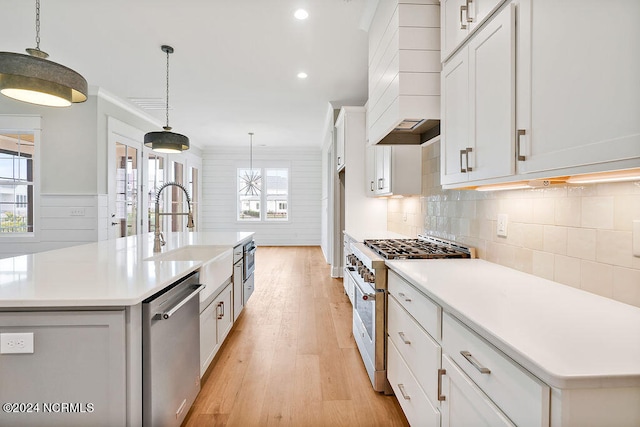 kitchen featuring range with gas stovetop, an island with sink, and dishwasher